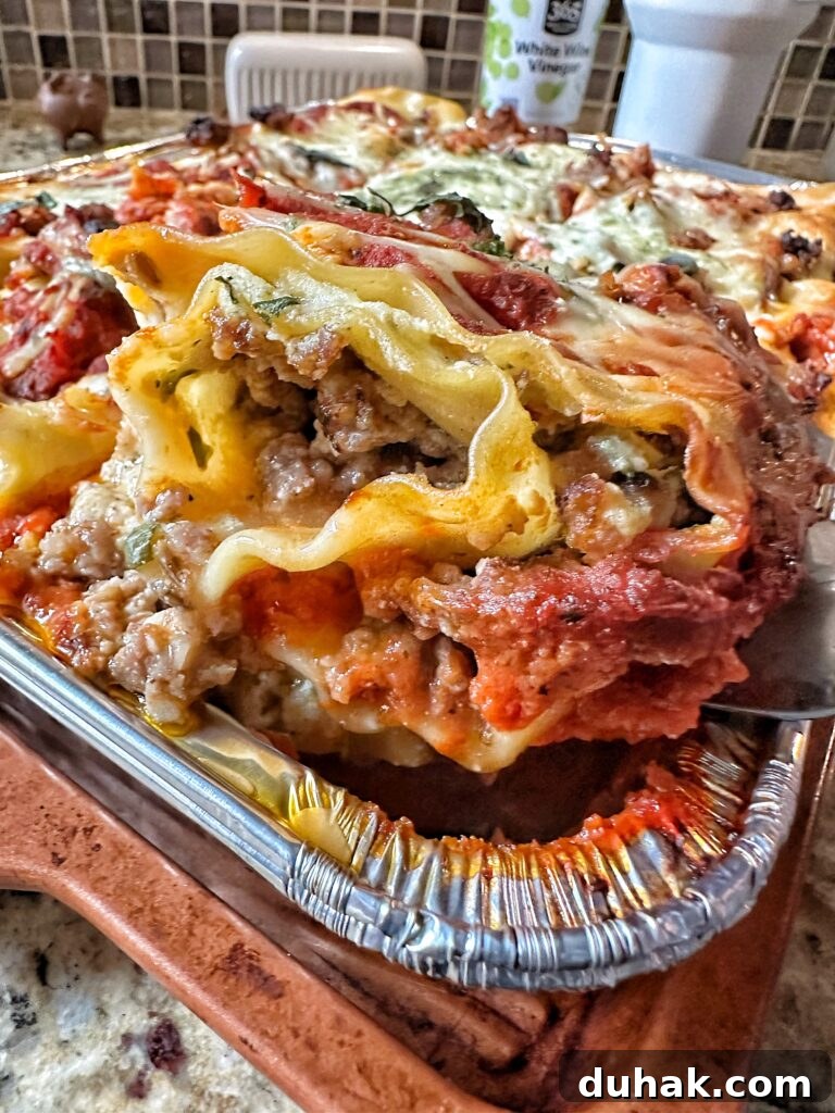 Authentic Italian Lasagna Recipe for Rich, Homemade Flavor 14 A piece of sausage lasagna being lifted out of the baking tin