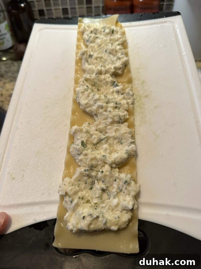 Authentic Italian Lasagna Recipe for Rich, Homemade Flavor 5 The cheese mixture spread out on a lasagna noodle on a white cutting board