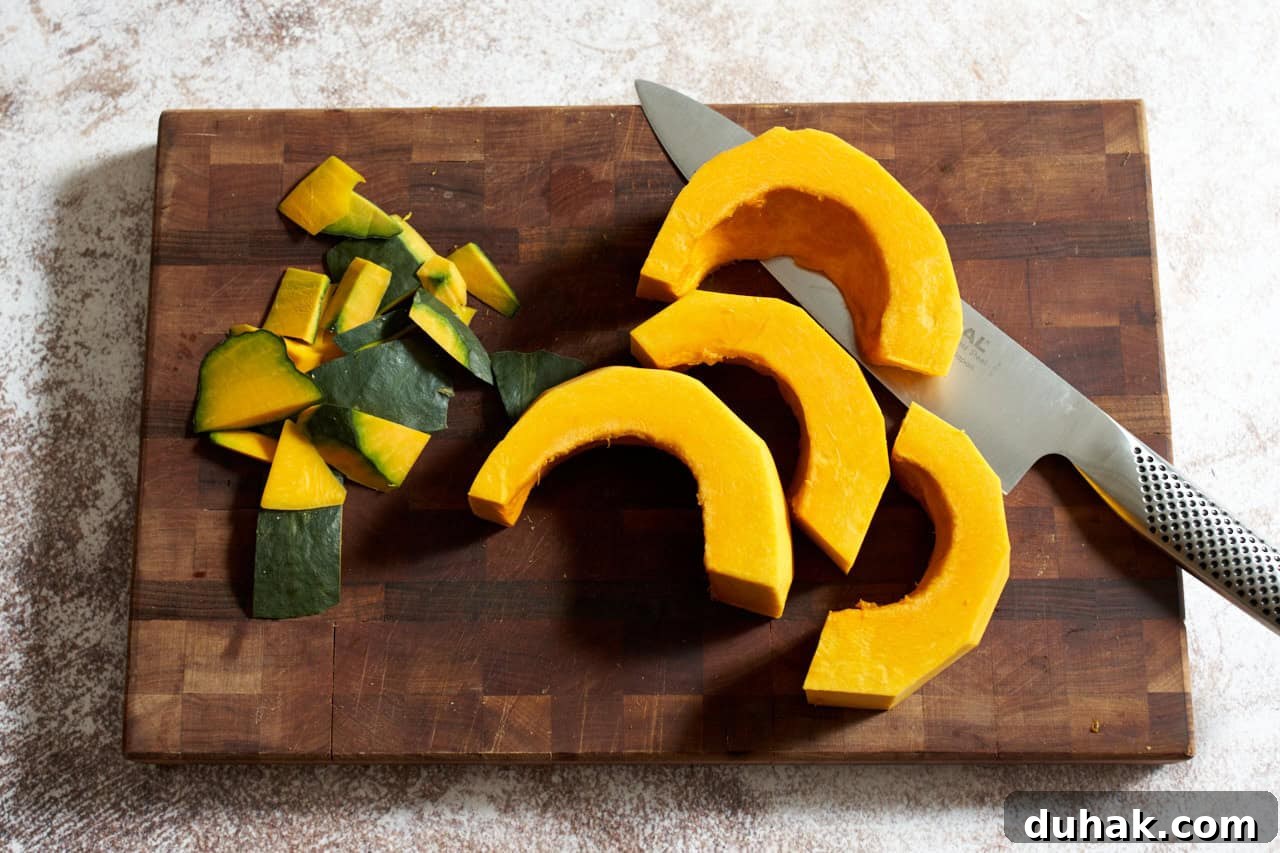 Gochujang Kabocha Squash Soup with Coconut Cream 4 Kabocha squash that has been peeled and sliced on a cutting board with a knife.