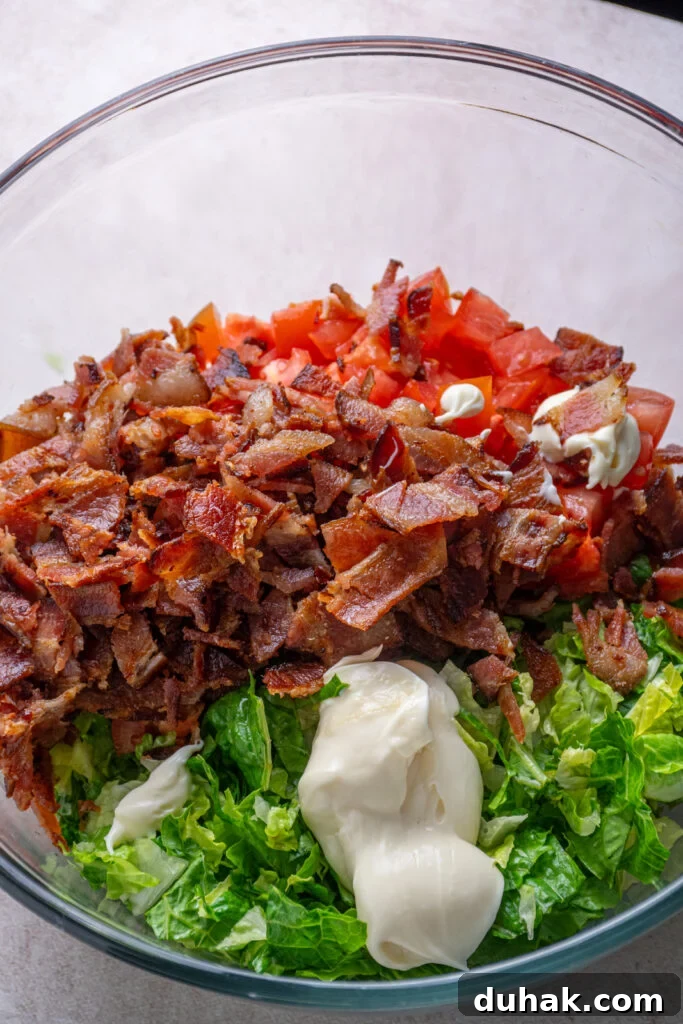 Adding mayo to the bowl of fillings.