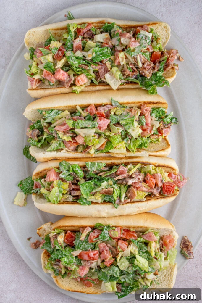Overhead view of a serving platter with four chopped BLT sandwiches.