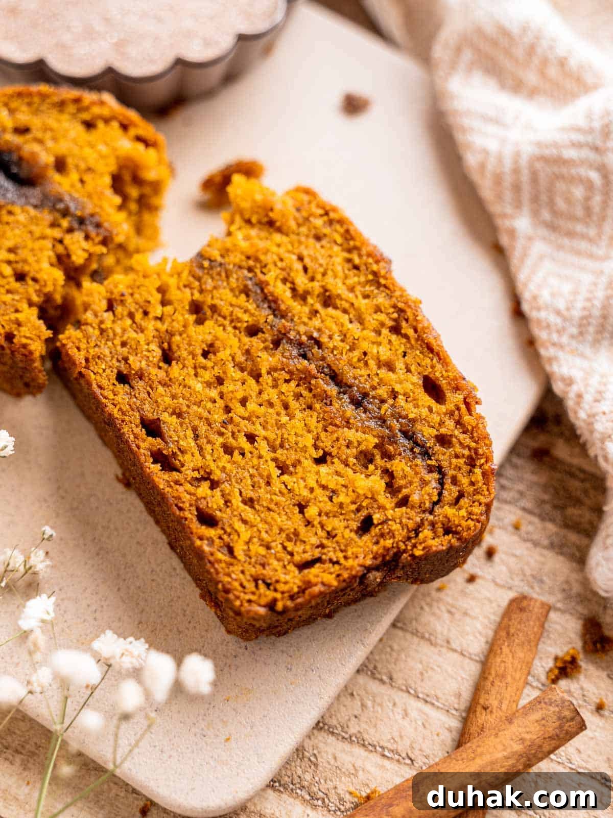 Pumpkin Snickerdoodle Quick Bread Recipe for Fall Baking 2 A slice of snickerdoodle pumpkin bread on a cutting board.