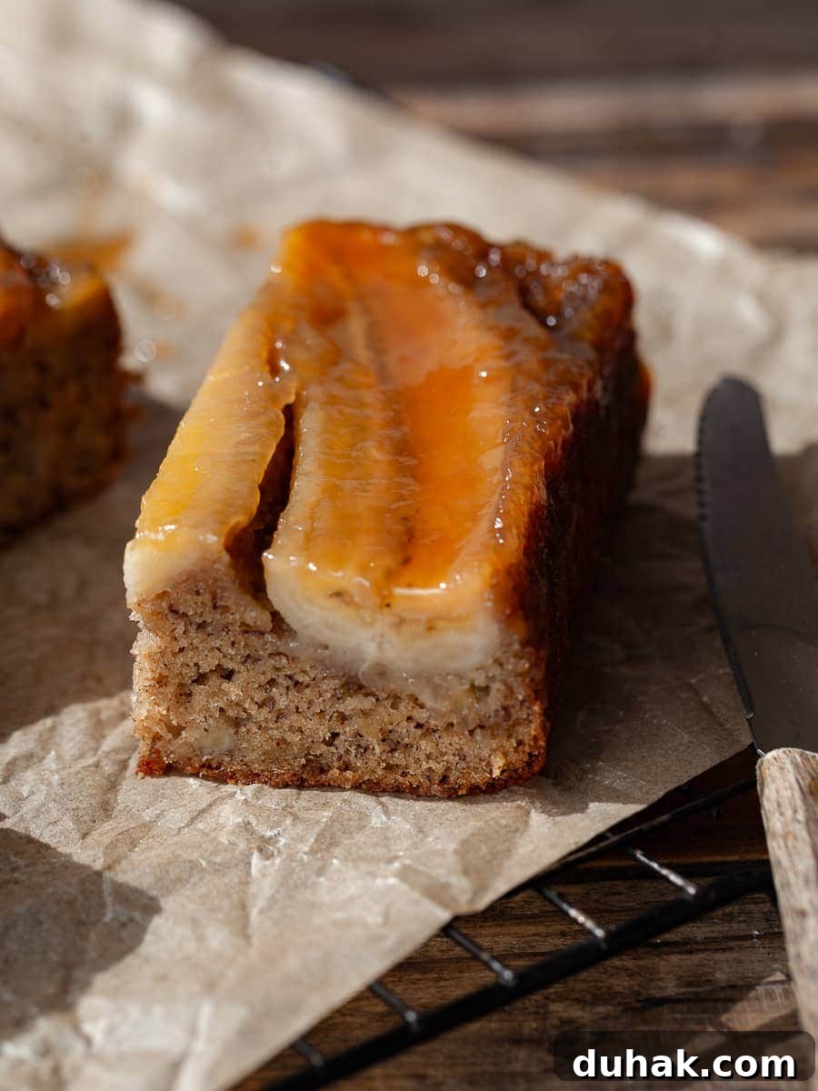 a close up photo of a slice of gluten free banana upside down cake with a small knife next to it