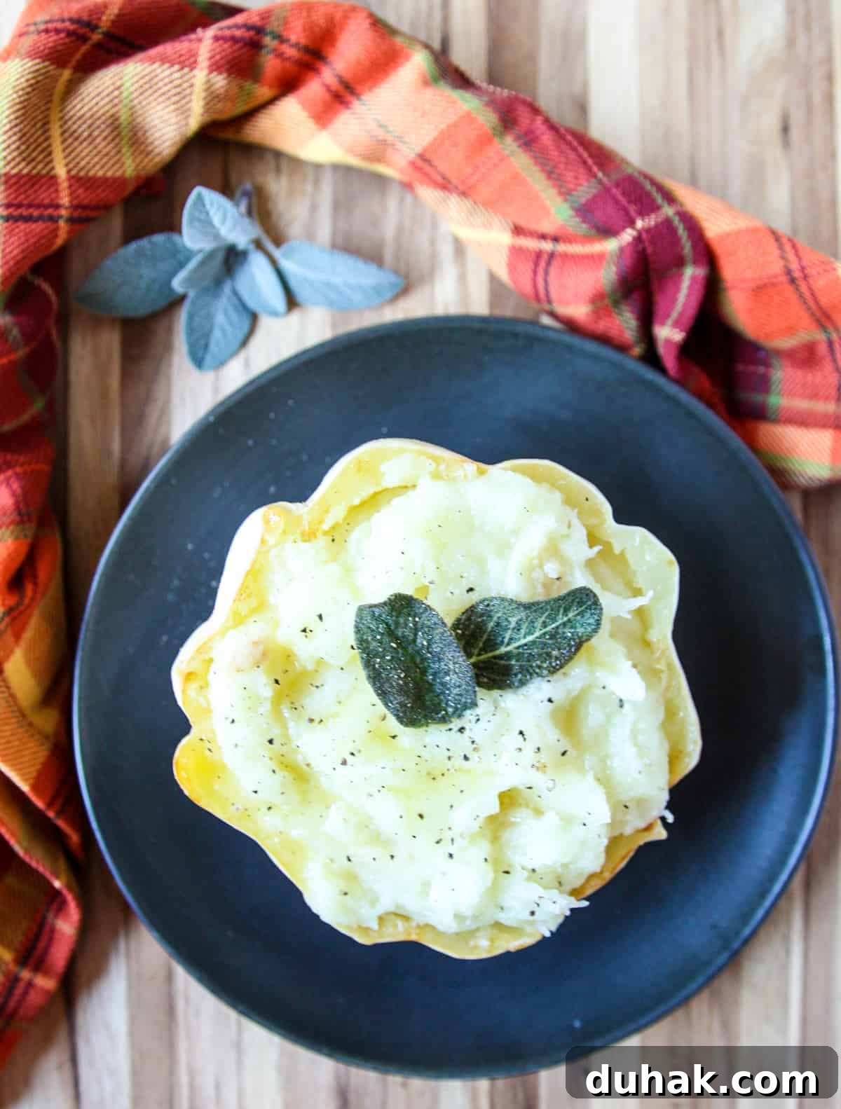 Mashed potato squash being served on a black plate.