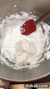 Stiff peak egg whites in a metal bowl