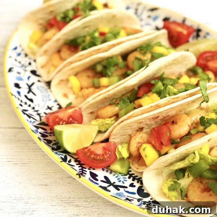 cajun prawn tacos with mango salsa served on blue and white platter