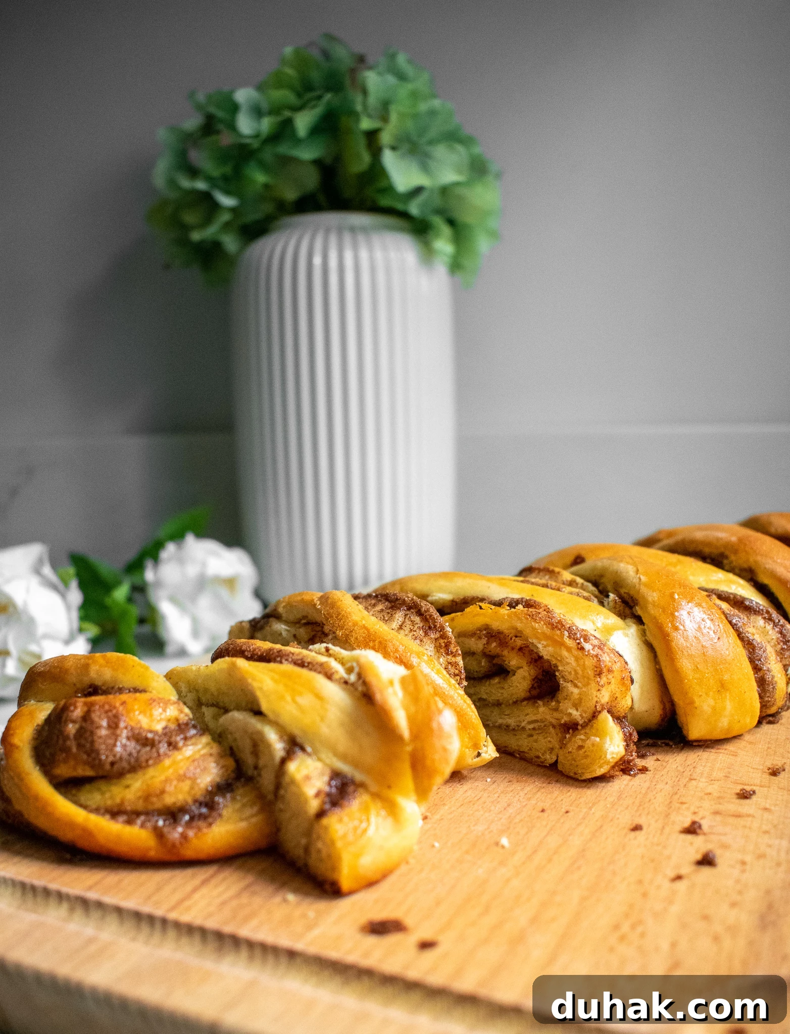 Cinnamon roll loaf cut into slices on a cutting board.