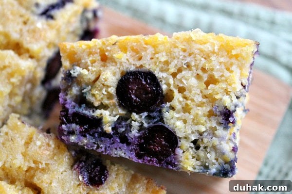 close up shot of a piece of blueberry cornbread