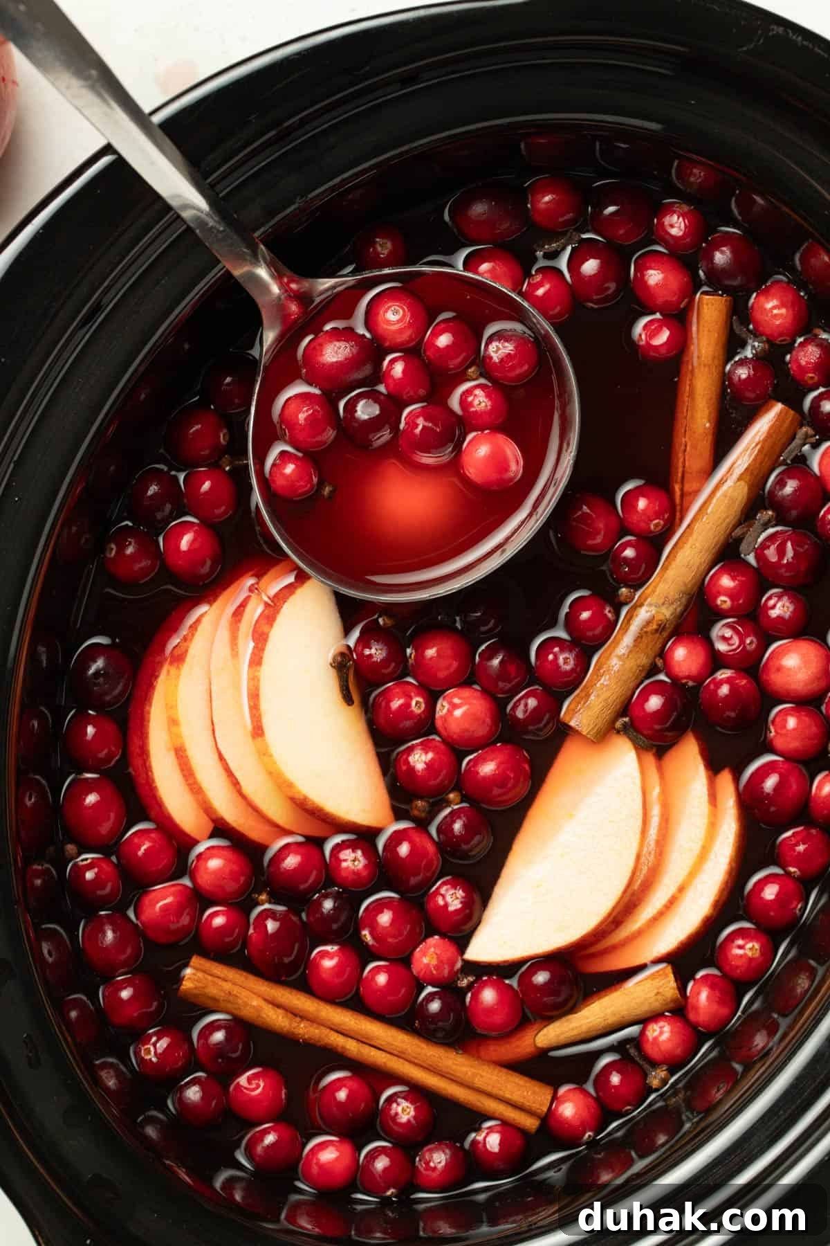 Alcohol-Free Wassail Recipe: Festive Mulled Apple Punch 5 Using a ladle to remove the wassail from the slow cooker.