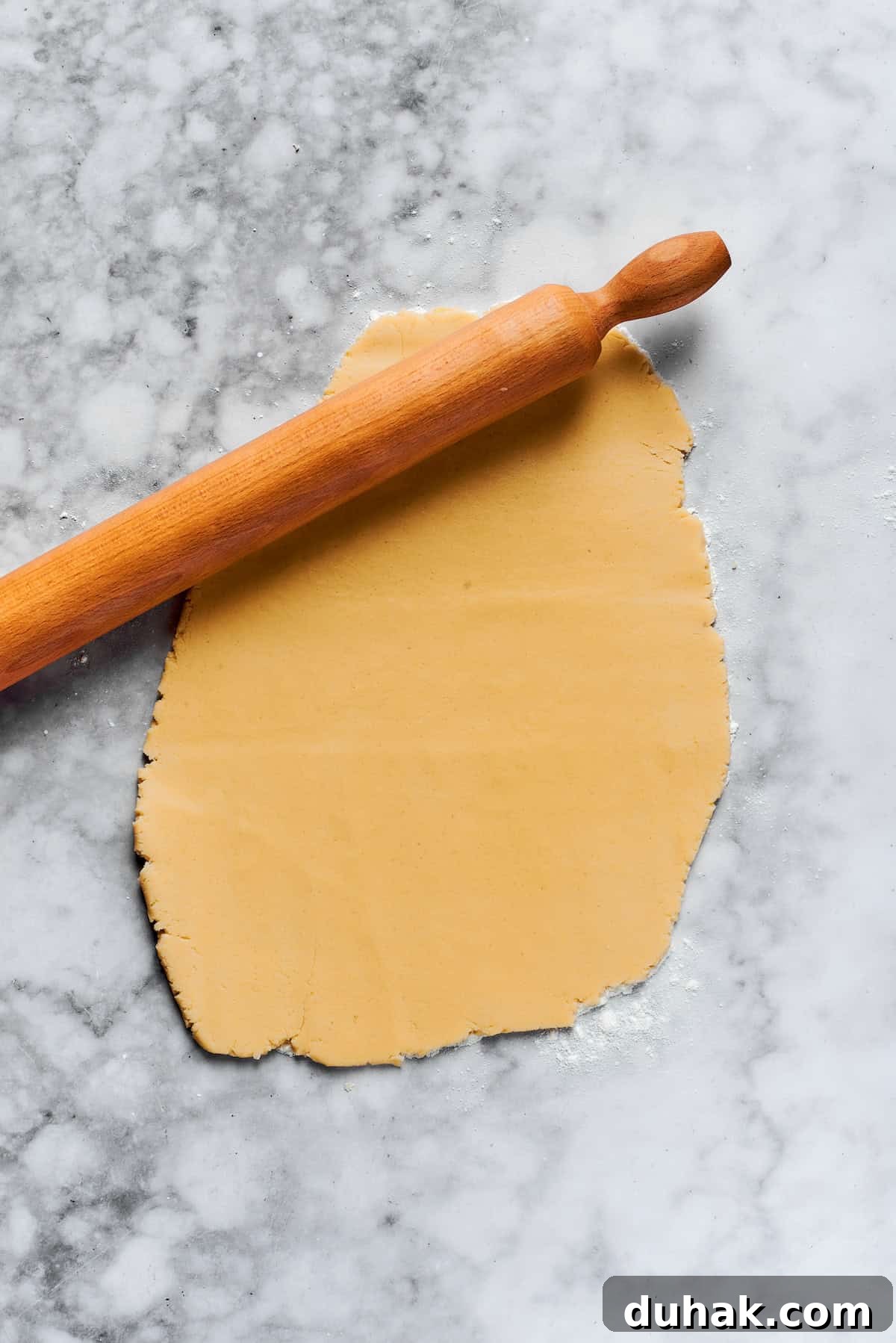 A rolling pin rolls out cookie dough.