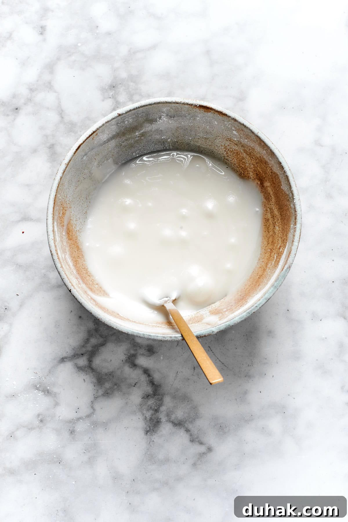 White icing mixed in a bowl.