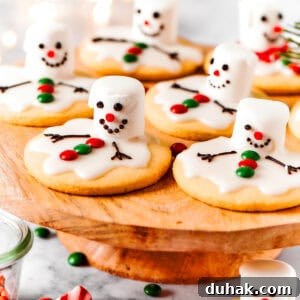 Melting snowman cookies are arranged on a cake plate.