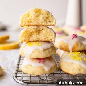 Lemon Ricotta Cookies Recipe — Soft, Zesty Citrus Cookies 14 Lemony Ricotta Cookies piled up like a tower with two at the top broken in half.