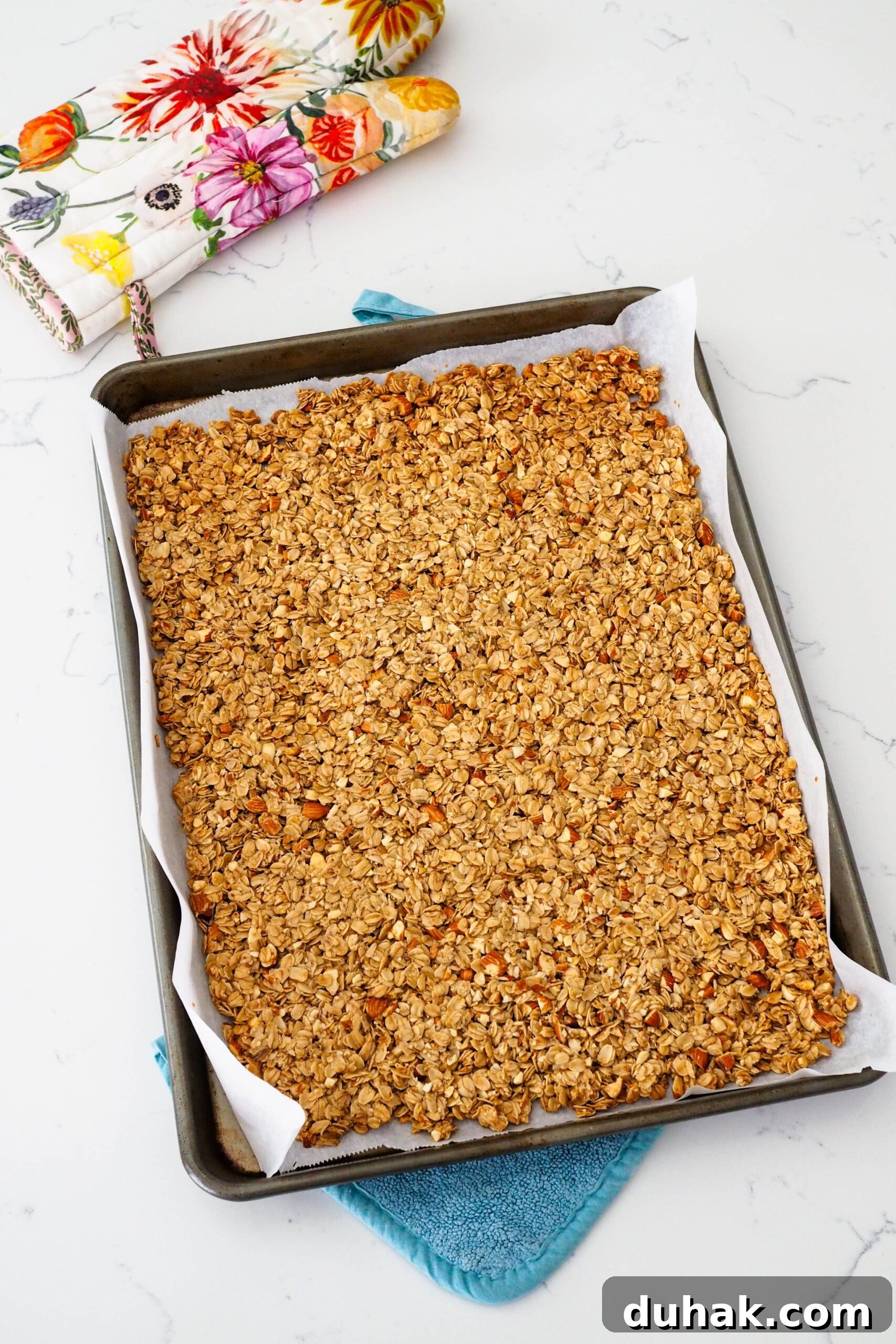 A thin layer of baked granola on a baking sheet.