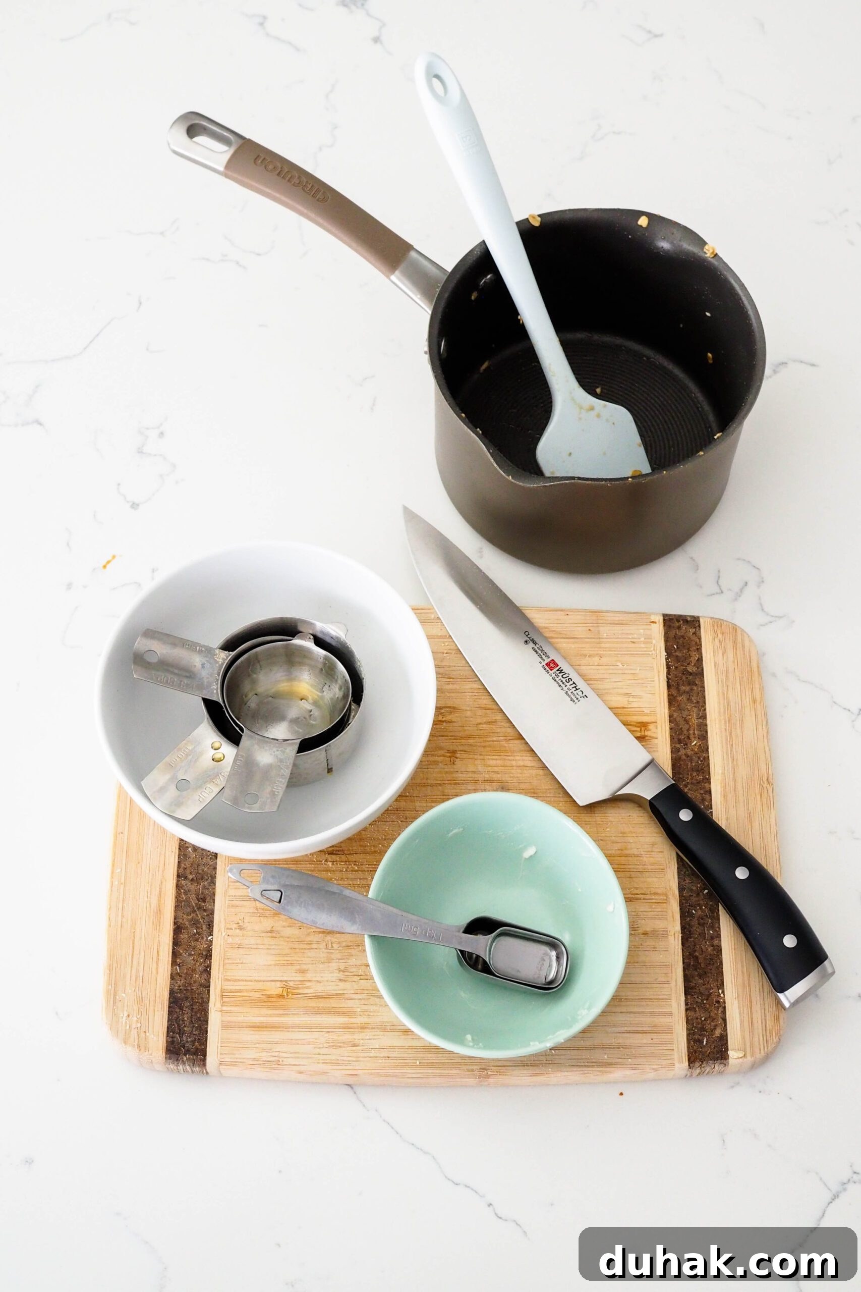 Dishes used to make vanilla almond granola on a quartz counter.