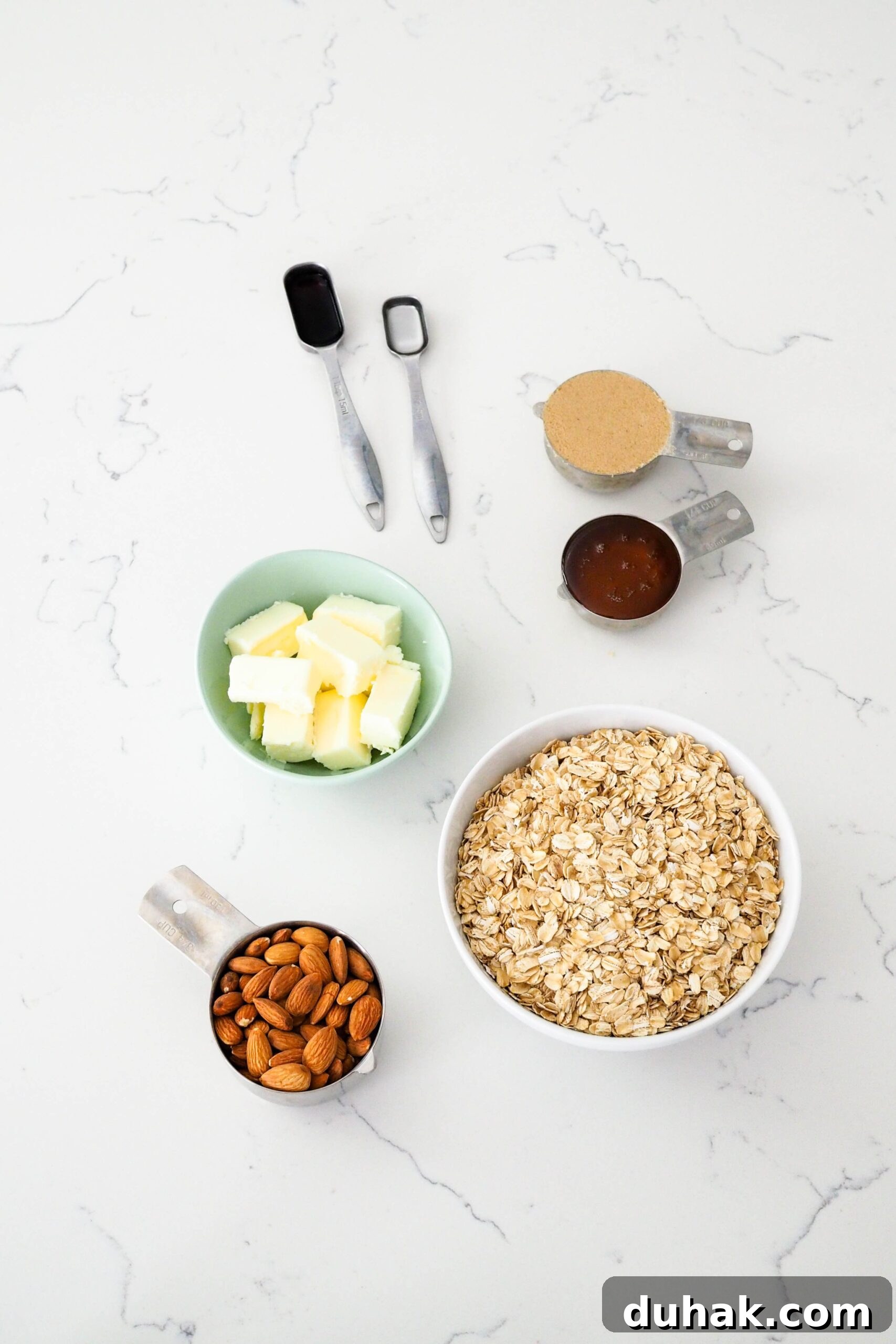 Ingredients for vanilla almond granola on a quartz countertop.