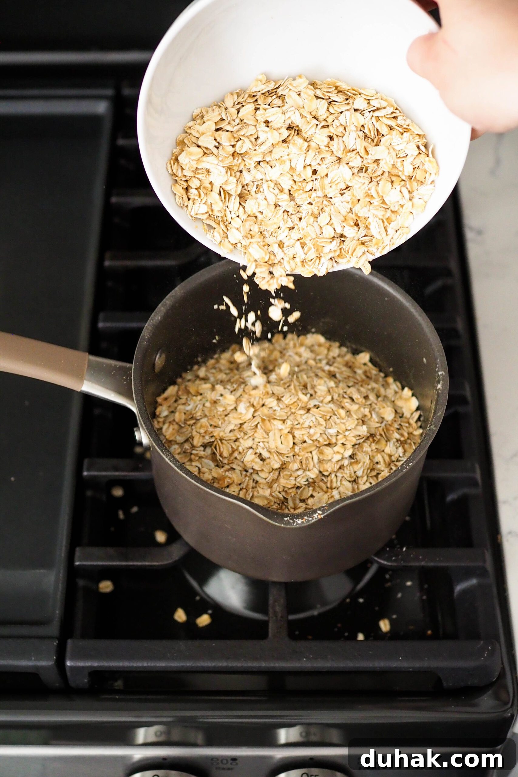Rolled oats are poured into a medium pot over the stove.