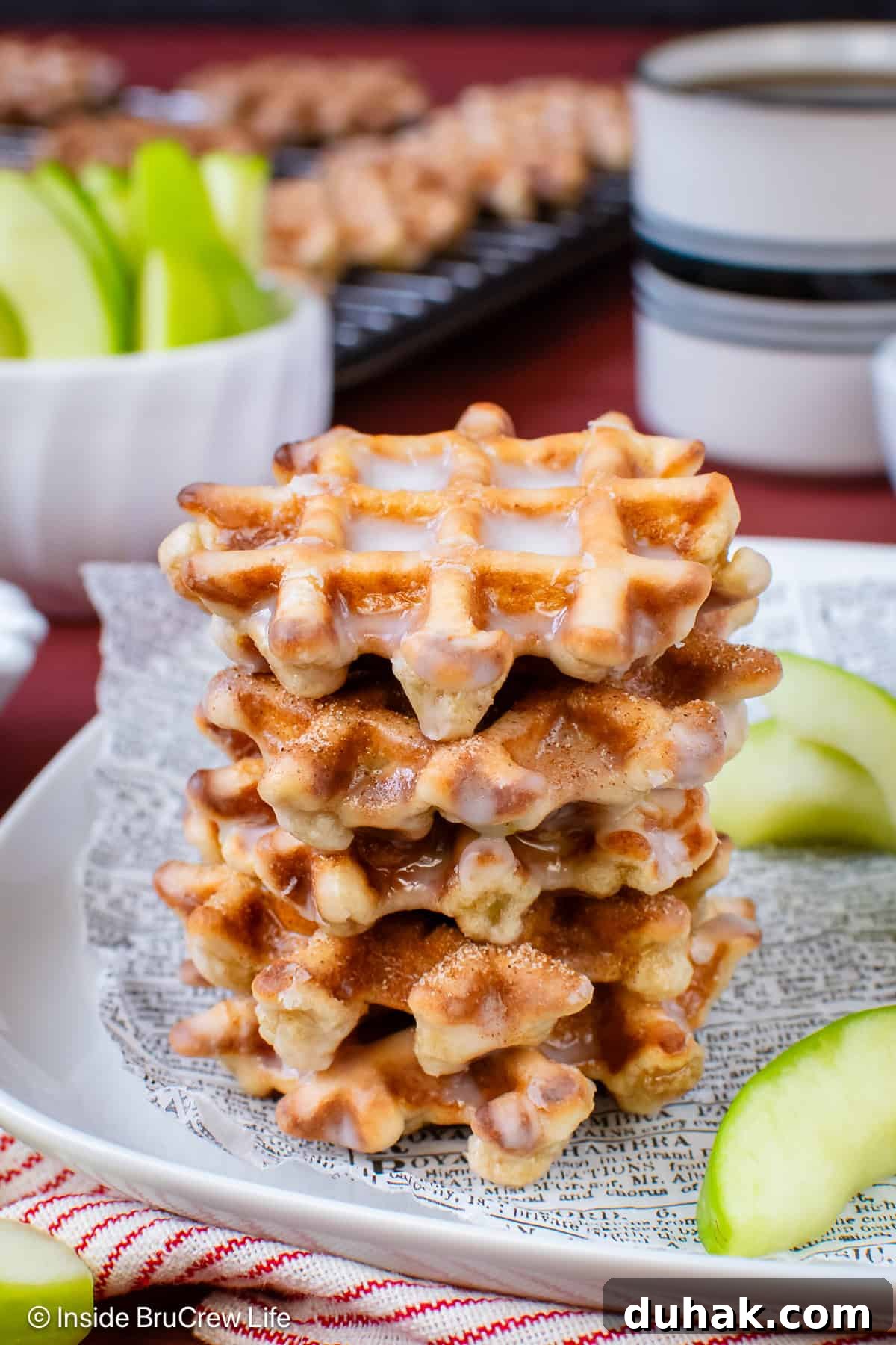 A stack of apple fritter waffles on a plate.