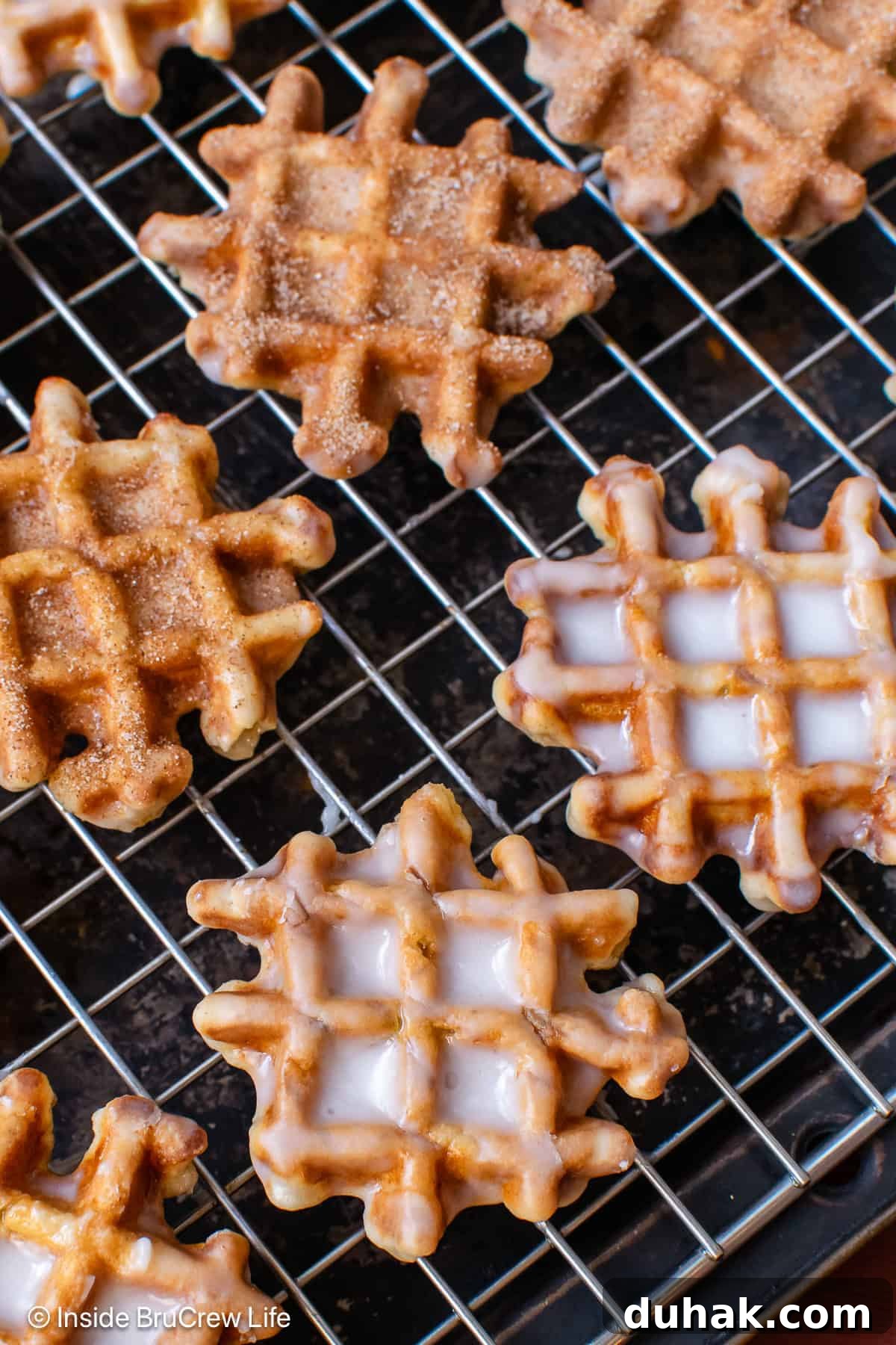 A cooling rack with glazed waffle donuts on it.