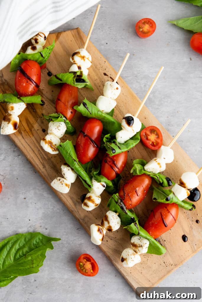 Caprese Skewers Recipe: Cherry Tomato, Mozzarella & Basil Bites 2 caprese skewers on cutting board