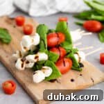 Caprese Skewers Recipe: Cherry Tomato, Mozzarella & Basil Bites 10 stack of caprese skewers on cutting board