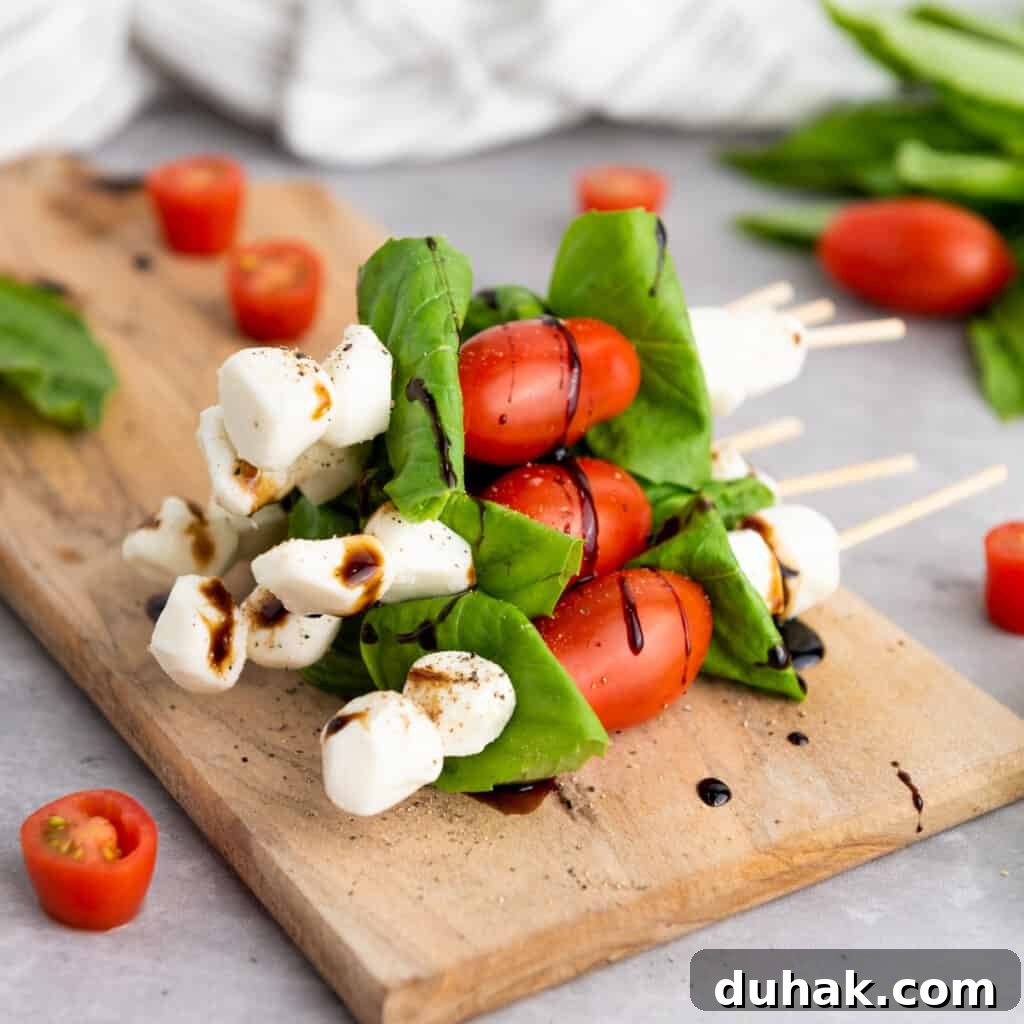 Caprese Skewers Recipe: Cherry Tomato, Mozzarella & Basil Bites 8 stack of caprese skewers on cutting board