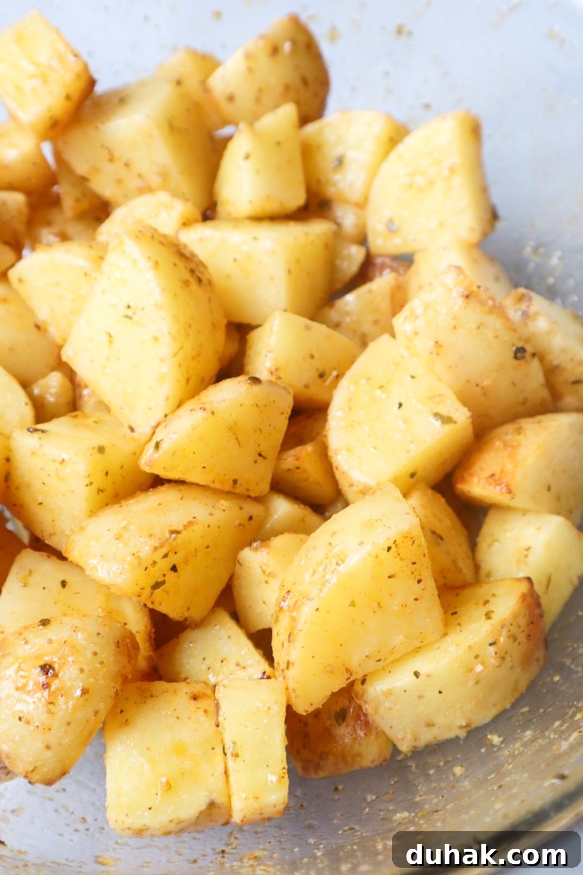 Crispy Greek-Style Potatoes in the Air Fryer 5 chopped potatoes in a bowl coated in the lemon herb greek seasoning