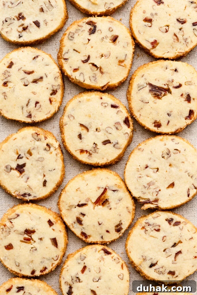 Overhead of baked pecan shortbread cookies covering a linen cloth.