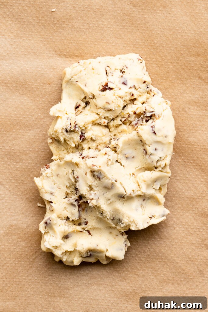 Shortbread cookie dough in a mound on a piece of parchment paper.