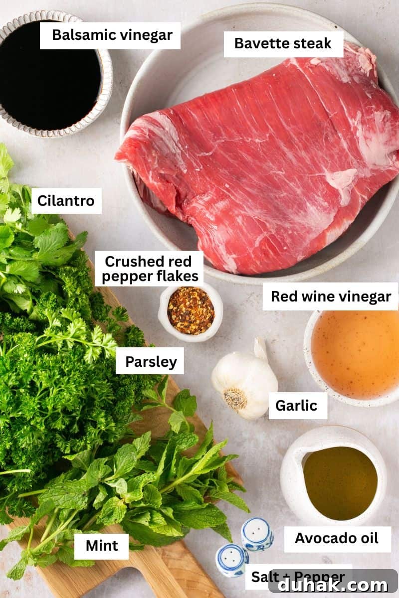 A piece of uncooked steak in a bowl surrounded by fresh herbs and spices.