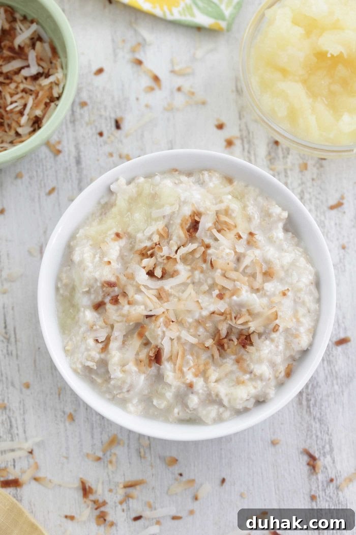 Pina Colada Overnight Oats Recipe for Tropical Breakfast 4 Piña colada overnight oats overhead shot in a white bowl with toasted coconut on top
