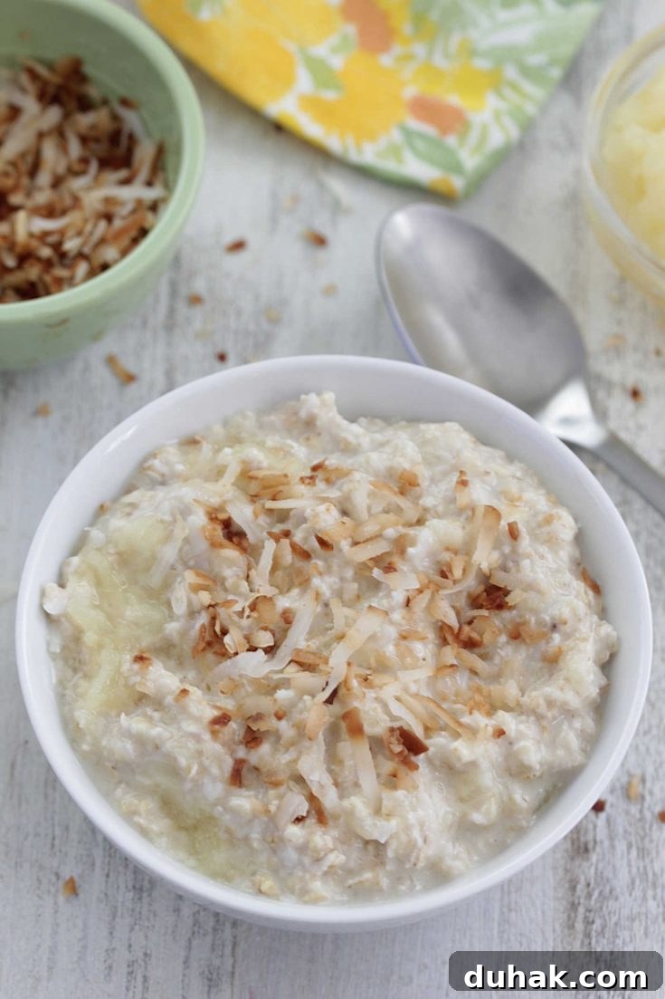 Piña colada overnight oats in a white bowl with toasted coconut on top