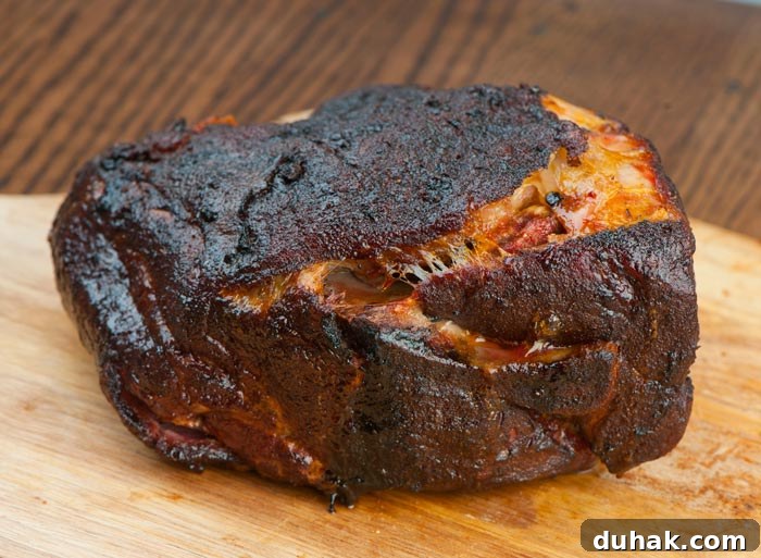 smoked pork butt resting on wooden chopping board