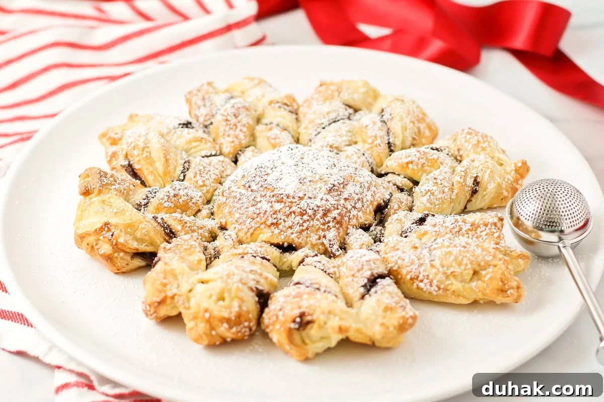 A puff pastry snowflake on a white plate.