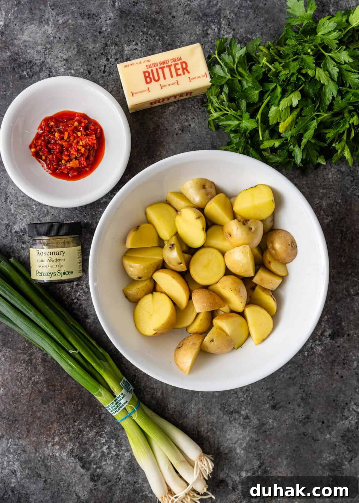 Spicy Calabrian Potatoes with Garlic and Chili Peppers 3 overhead: ingredients to make potatoes and peppers in bowls on a counter