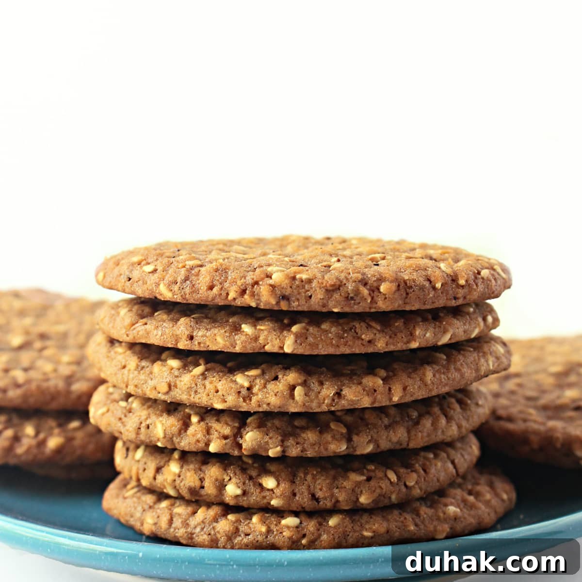 Stack of thin sesame cookies on a blue plate.