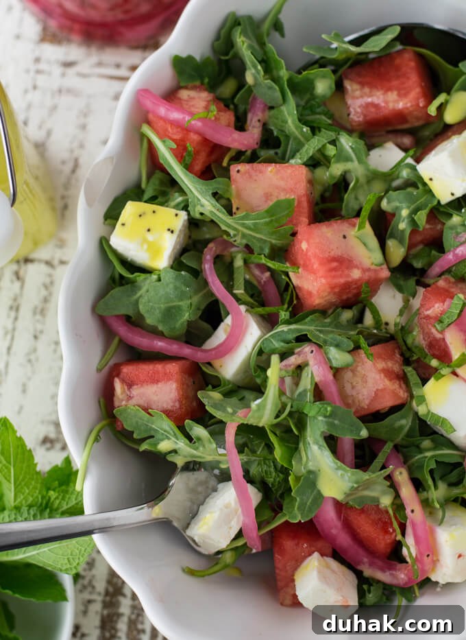 Pickled Red Onions top a watermelon arugula salad.
