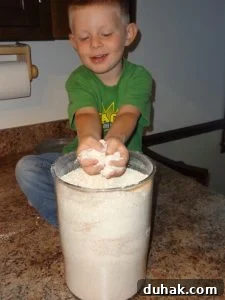 kid playing in canister of homemade flour