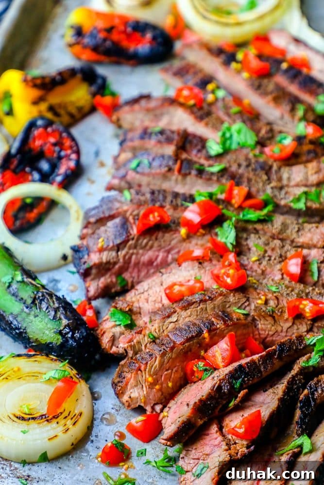Grilled steak with peppers and onions on a baking sheet, the Best Grilled Carne Asada Recipe Ever.