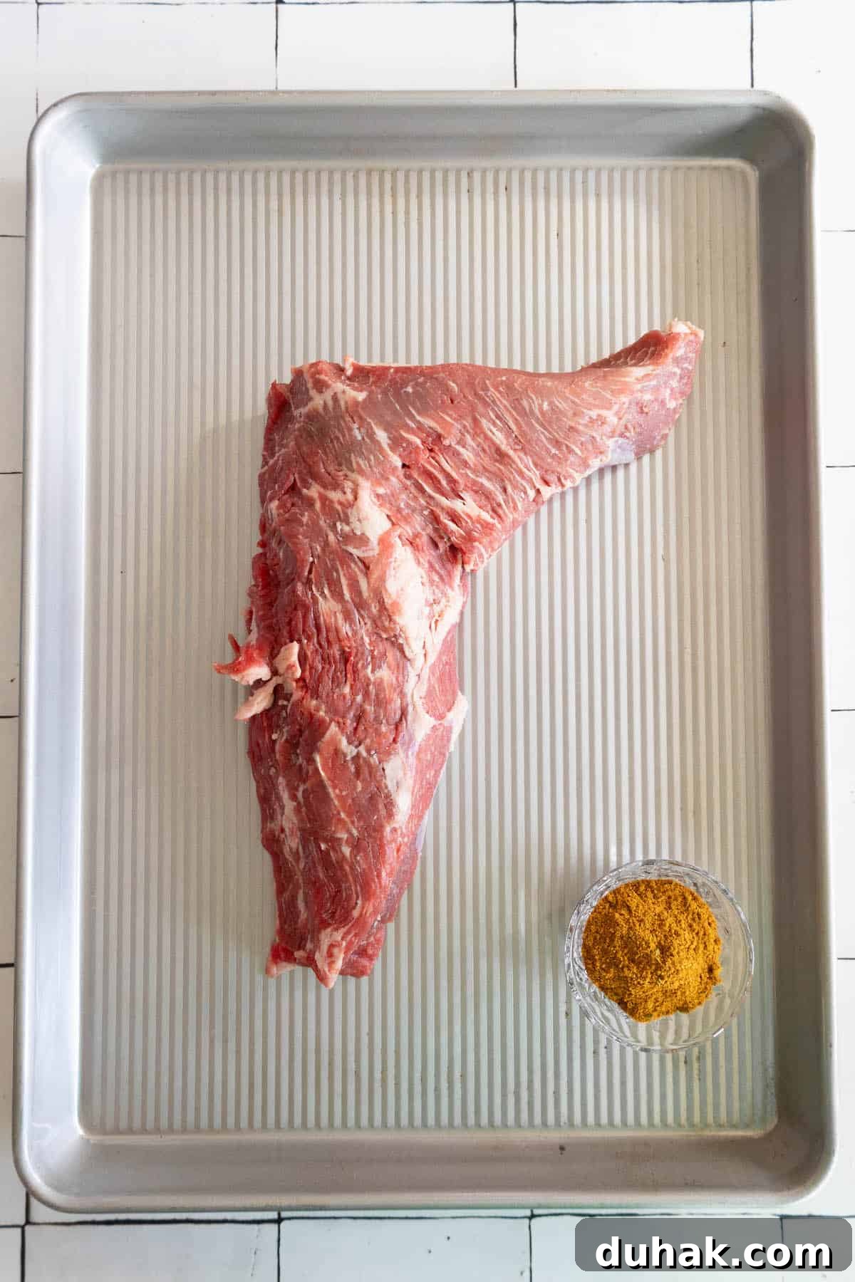 A reverse seared tri-tip steak on a baking sheet.