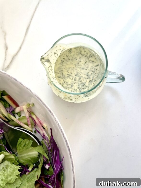 an overhead shot of dill dressing in a glass container