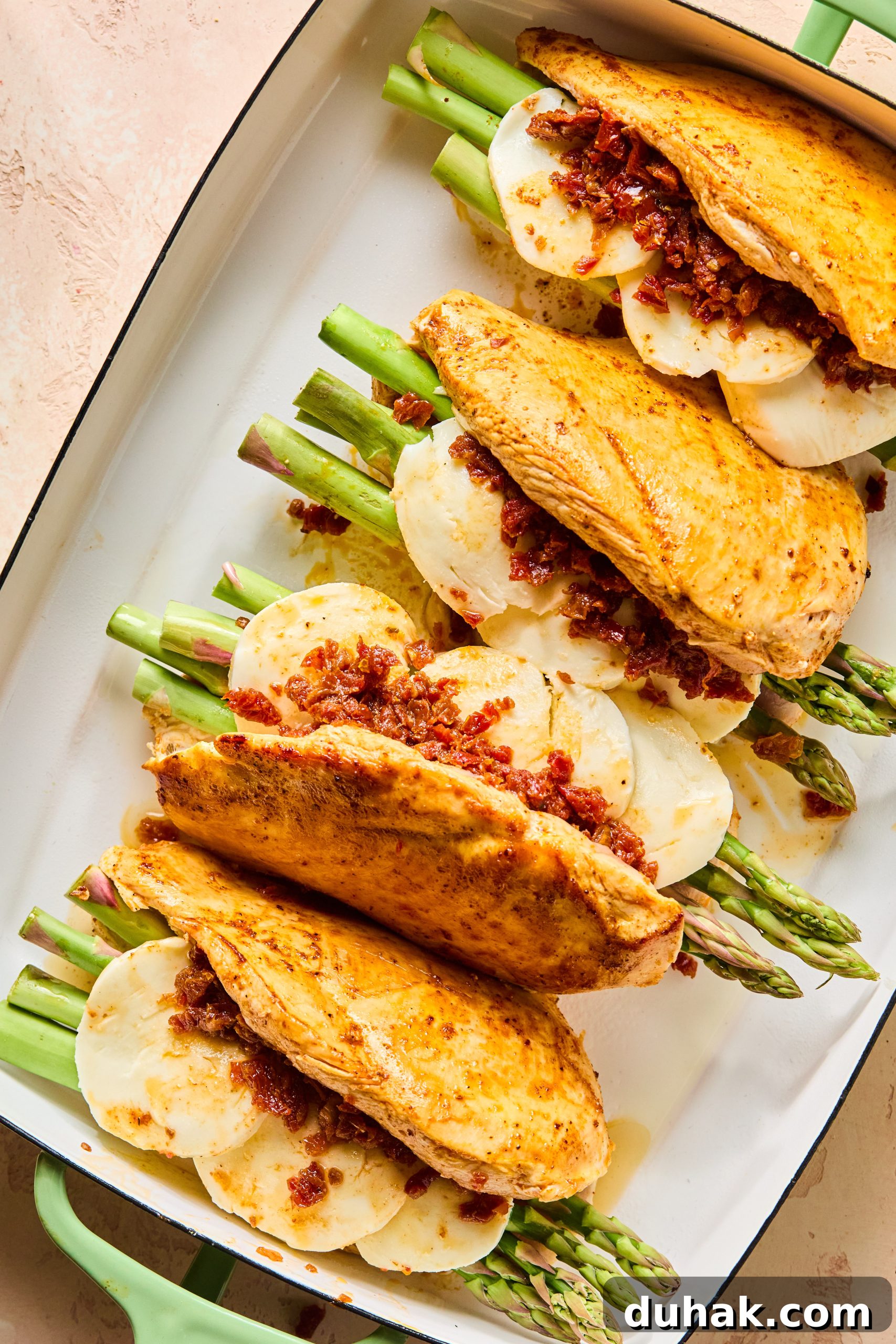 Asparagus and Sun-Dried Tomato Stuffed Chicken with Pesto and Cheese 9 4 seasoned and seared chicken breasts filled with asparagus, sliced mozzarella and sun-dried tomatoes sitting in a large baking dish