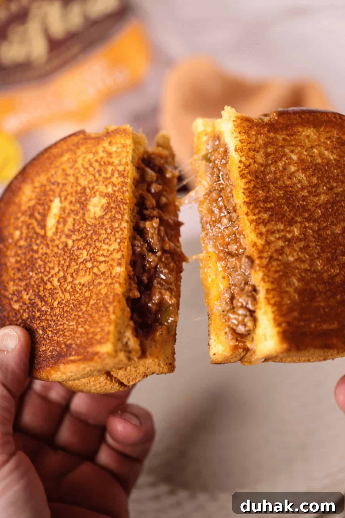 Sloppy Joe Grilled Cheese Sandwich Recipe for Comfort Dinner 3 A person holding the dish in their hands.