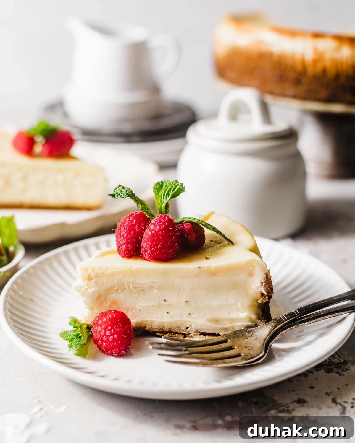 Silky Mascarpone Cheesecake Recipe with Luscious Cream Filling 8 slices of mascarpone cheesecake on plates with forks.