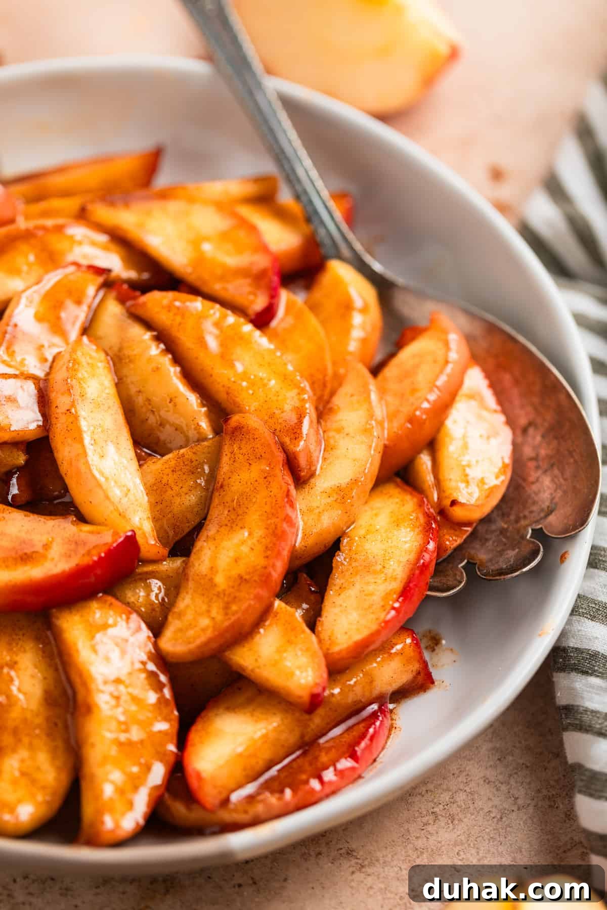 Dish with cinnamon air fryer apples with serving spoon.