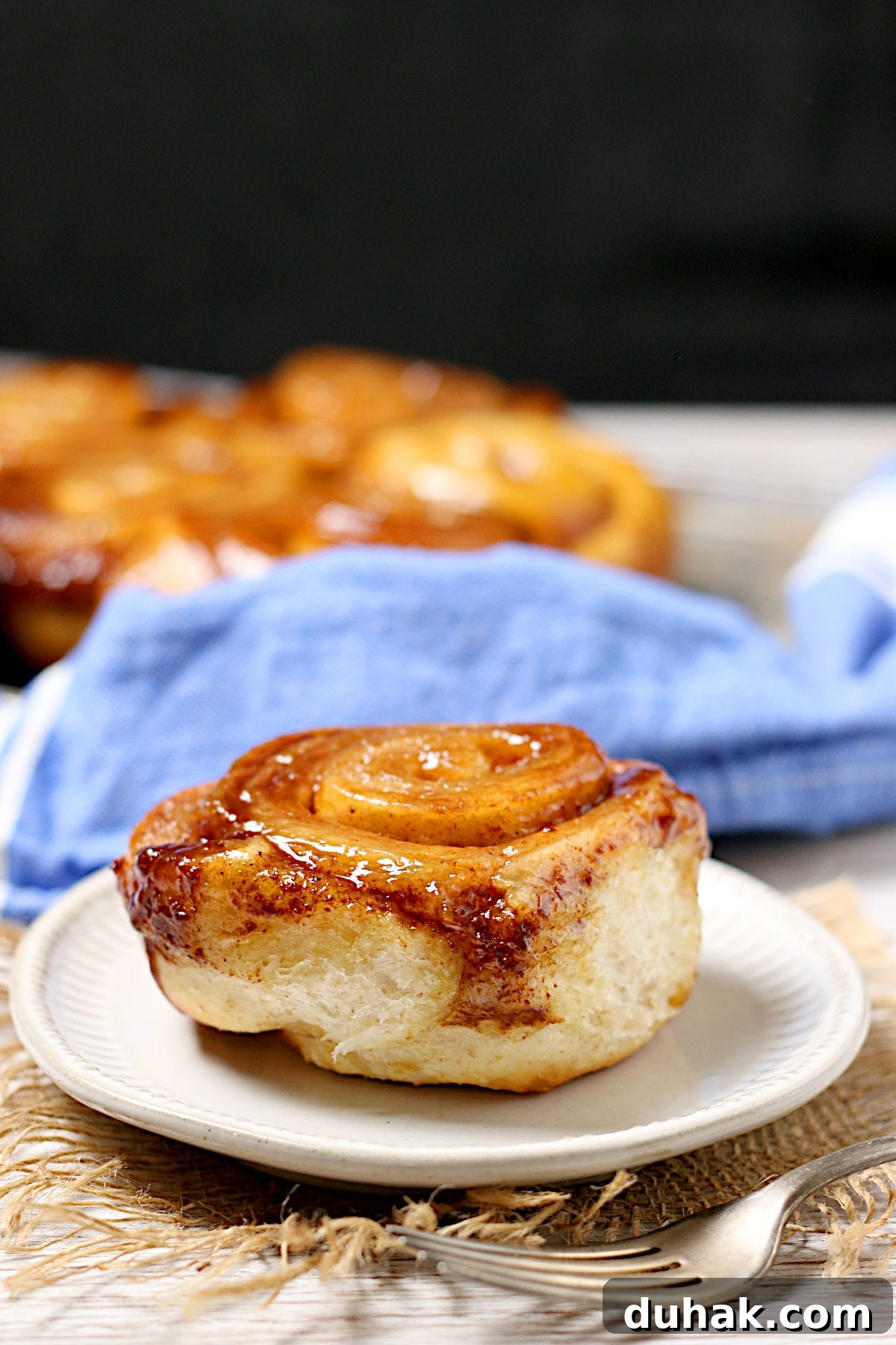 Cinnamon Toast Focaccia Recipe: Crispy Sweet Breakfast Bread 6 A homemade Overnight Sticky Bun on a small, white plate.