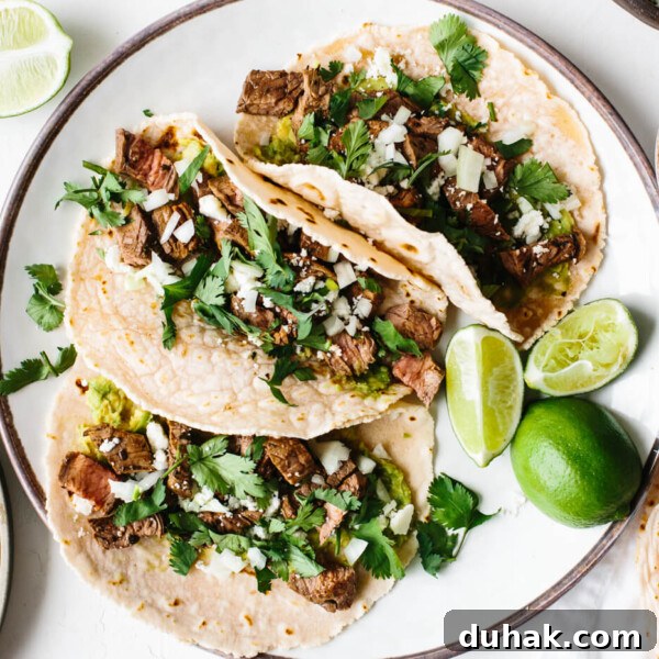 A plate of carne asada tacos next to tortillas and cheese.