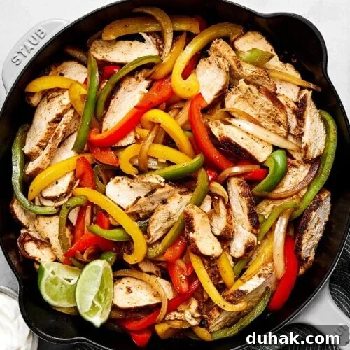 Chicken fajitas in a black skillet.