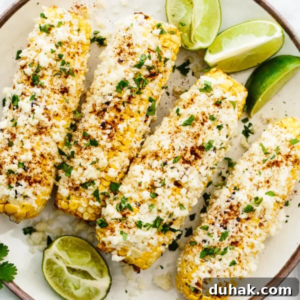 A plate of elote with cheese and lime