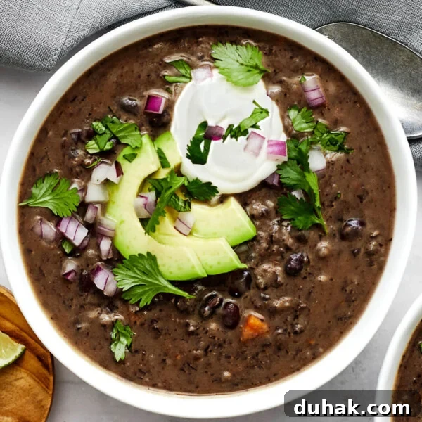A white bowl of black bean soup